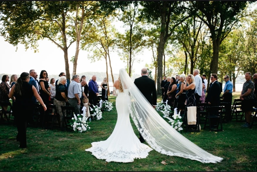 Bride and groom walking down the lakefront aisle